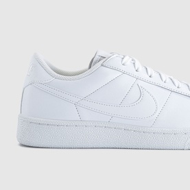 Nike low-top trainer in triple white leather with tonal Swoosh logo and white rubber sole, close-up detail view