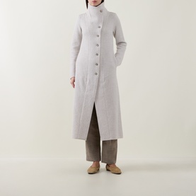 Model wearing Transit white wool longline coat with button front, styled with wide-leg trousers and flat shoes