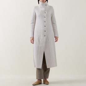 Model wearing Transit white 100% virgin wool longline coat with stand collar, button front, and front slit, styled with grey trousers