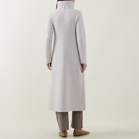 Model wearing Transit white 100% virgin wool longline coat with high neck and centre seam detail, styled with taupe trousers