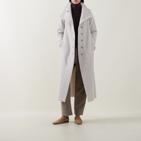 Model wearing Transit white wool longline coat with button front, styled with dark turtleneck, taupe trousers and flat shoes