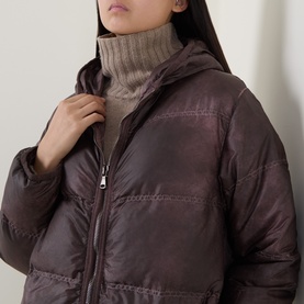 Model wearing Transit rust puffer coat with hood and zip fastening, styled with a taupe ribbed roll-neck jumper underneath