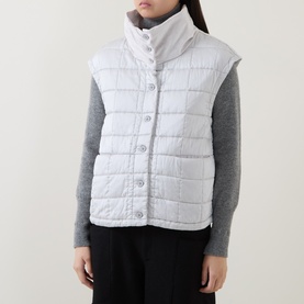Model wearing Transit Gilet in ice white, quilted sleeveless style with button front, styled with grey knit sweater underneath