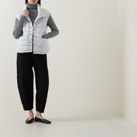 Model wearing Transit Ice gilet with grey turtleneck, black tapered trousers and black flat shoes