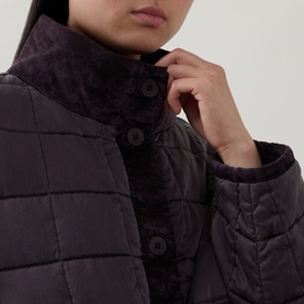 Model wearing Transit quilted silk jacket in Choco, close-up of button-up collar with tonal leopard-print lining detail.