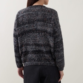 Model wearing a dark grey marl striped chunky knit jumper, back view, styled with black trousers