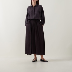 Model wearing Transit choco wool midi skirt with gathered waist, styled with matching shirt and black ballet flats