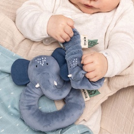 Trixie blue elephant ring rattle soft toy held by a baby, featuring textured fabric details and trunk handle
