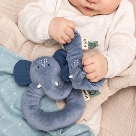 Trixie blue elephant ring rattle soft toy held by a baby, featuring textured plush fabric and trunk detail