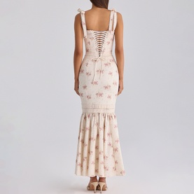 Model wearing House of CB Ivory Vintage Rose floral maxi dress, showing lace-up back bodice, bow shoulder straps, and ruffled hem detail.