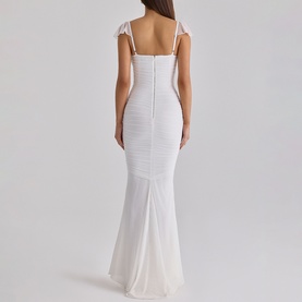 Model wearing House of CB white maxi dress with ruched bodice, cap sleeves, and fishtail hem, shown from the back.