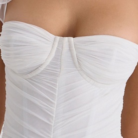 Model wearing House of CB white ruched mesh strapless bodice with sweetheart neckline and structured cup detail.