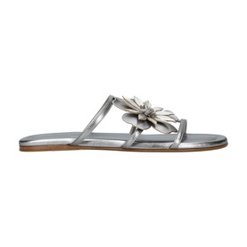Silver flat sandal with T-bar strap, floral embellishment at toe post, and tan leather insole
