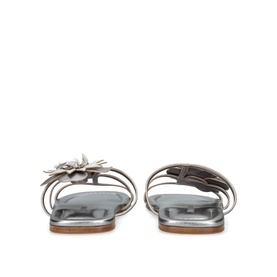Silver metallic flat sandals with multi-strap design and floral embellishment, shown from rear angle with tan leather insole