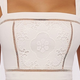 Model wearing House of CB white bandeau top with broderie anglaise lace panel detail and ladder trim hem.