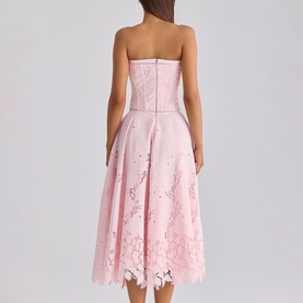 Model wearing House of CB pink strapless midi dress with floral lace hem detail, back view showing structured bodice and full skirt