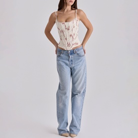 Model wearing House of CB Ivory Vintage Rose corset top with floral print, styled with light wash ripped straight-leg jeans.