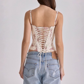 Model wearing House of CB Ivory Vintage Rose floral corset top with lace-up back detail, styled with blue denim jeans.