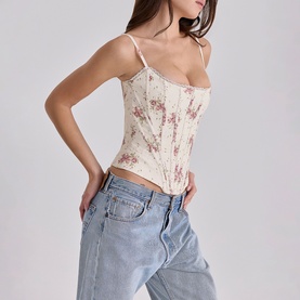 Model wearing House of CB Ivory Vintage Rose floral corset camisole top, styled with light blue low-rise jeans.
