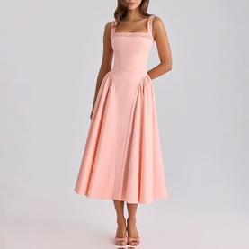 Model wearing House of CB peach midi dress with square neckline, wide straps with trim detail, and full A-line skirt, styled with heeled sandals.