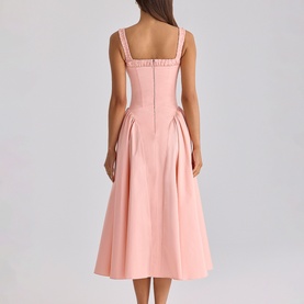 Model wearing House of CB peach midi dress with square neckline, wide straps, structured bodice and full pleated skirt, back view