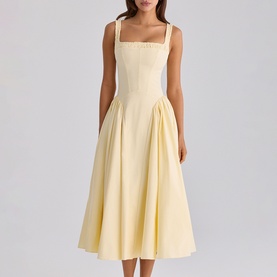 Model wearing House of CB lemon midi dress with square neckline, tie straps, fitted bodice and full pleated skirt