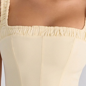 Model wearing House of CB lemon corset top, close-up detail of ruched square neckline and structured boning panels.