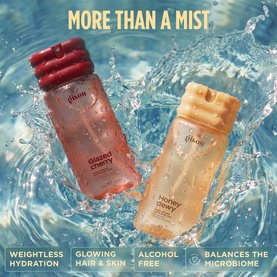 Gisou Body Mist duo in Glazed Cherry and Honey Cherry variants, submerged in water splash, highlighting weightless hydration formula