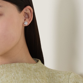Model with Kate Spade Spade Flower Pav&eacute; Studs in silver-tone, cubic zirconia flower-shaped stud earrings, worn with a sage green top.
