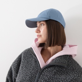 Model with Lululemon Classic Baseball Cap in Steel Blue, styled with a pink hoodie and grey fleece jacket