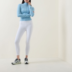 Model wearing Lululemon Seafoam zip-up fitted jacket with white cropped leggings and grey running trainers.