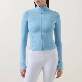 Model wearing Lululemon seafoam zip-up fitted jacket with seam detailing, styled with white leggings
