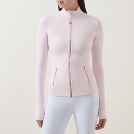 Model wearing Lululemon Pink Pearl jacket with gold zip and hardware, styled with white leggings