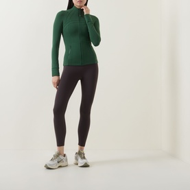 Model wearing Lululemon Ivy Grove zip-up jacket with ribbed texture, styled with dark leggings and grey trainers.