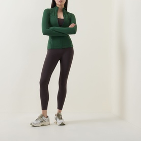 Model wearing Lululemon Ivy Grove jacket with arms crossed, styled with dark leggings and white trainers