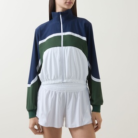 Model wearing Lululemon Court Champ UV-Protective Tennis Jacket in White/Ivy Grove/Club Blue, styled with white shorts