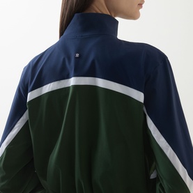 Model wearing Lululemon Court Champ UV-Protective Tennis Jacket in White/Ivy Grove/Club Blue, showing colour-block back detail with funnel neck.