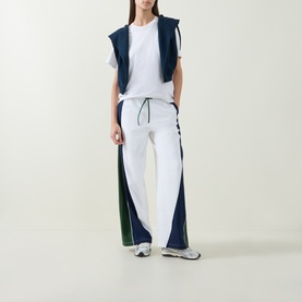 Model wearing Lululemon white, ivy grove and club blue colour-block wide-leg trousers with white tee and navy vest top.