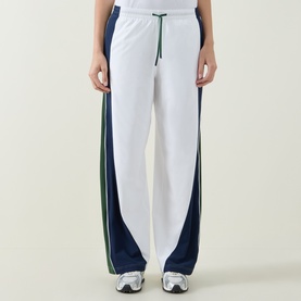 Model wearing Lululemon wide-leg tracksuit trousers in white with navy and green side panel detailing, drawstring waist.