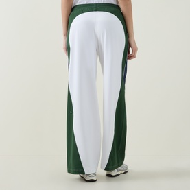 Model wearing Lululemon leggings in white and ivy grove green colourblock design, wide-leg silhouette, shown from behind with trainers.