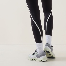 Model wearing Lululemon black and light ivory leggings with contrast seam detail, styled with white socks and light grey trainers