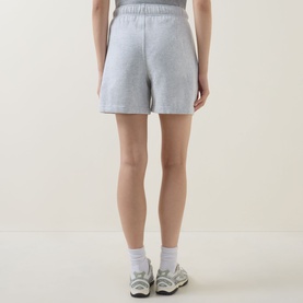 Model wearing Lululemon shorts in Heathered Core Ultra Light Grey, styled with white socks and grey trainers, rear view.