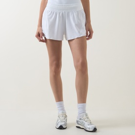 Model wearing Lululemon white shorts, styled with white ankle socks and grey trainers