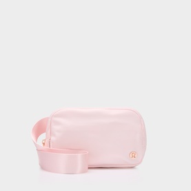 Lululemon Pink Pearl crossbody belt bag with rose gold logo hardware and wide matching shoulder strap