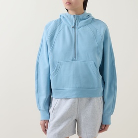 Model wearing Lululemon seafoam half-zip hoodie sweatshirt with kangaroo pocket, styled with grey shorts