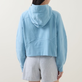 Model wearing Lululemon seafoam cropped hoodie, back view, styled with light grey shorts