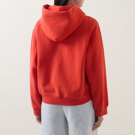 Model wearing Lululemon Cherry Ember hoodie sweatshirt, rear view, styled with light grey sweatpants