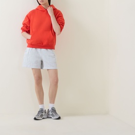 Model wearing Lululemon Cherry Ember hoodie with light grey shorts and grey trainers, white ankle socks