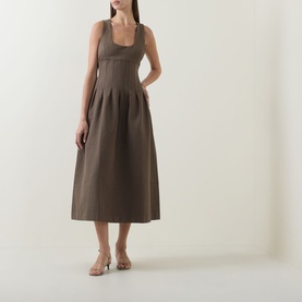 Model wearing Odd Muse Cinched Pleated Dress in Mushroom, featuring scoop neckline, boned bodice, and pleated midi skirt, styled with nude heels.