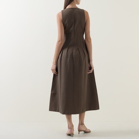 Model wearing Odd Muse Cinched Pleated Dress in Mushroom, showing rear view of boned bodice, pleated midi skirt, styled with beige heels.
